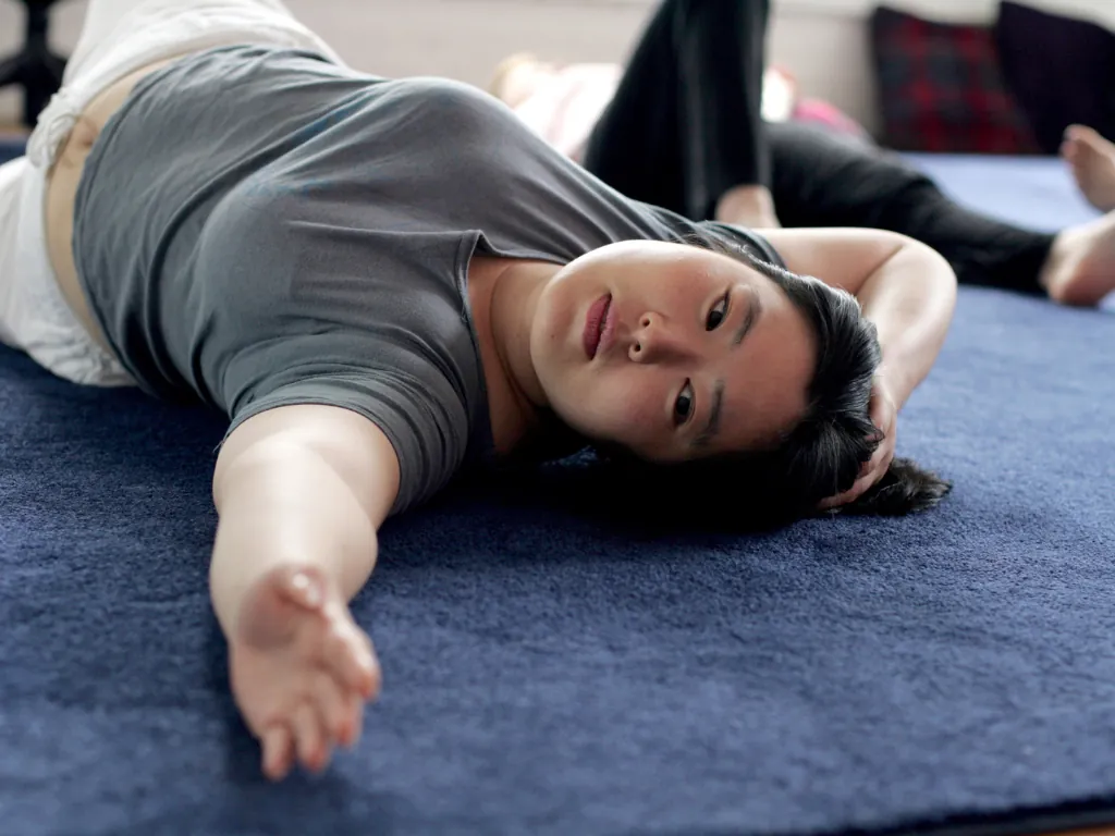 A student resting into a gentle Feldenkrais floor lesson