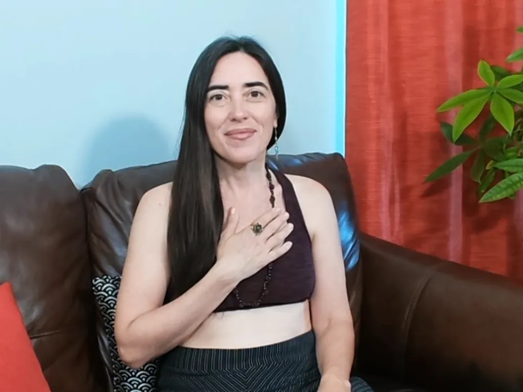 Dayana teaching a live practice, one hand resting on her heart